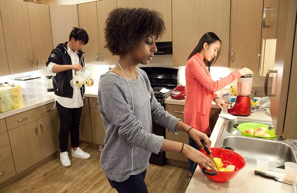 छात्रावास की रसोई में खाना पकाने वाले छात्र
